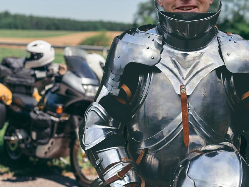 Guy wearing suit of armour next to motorcycle